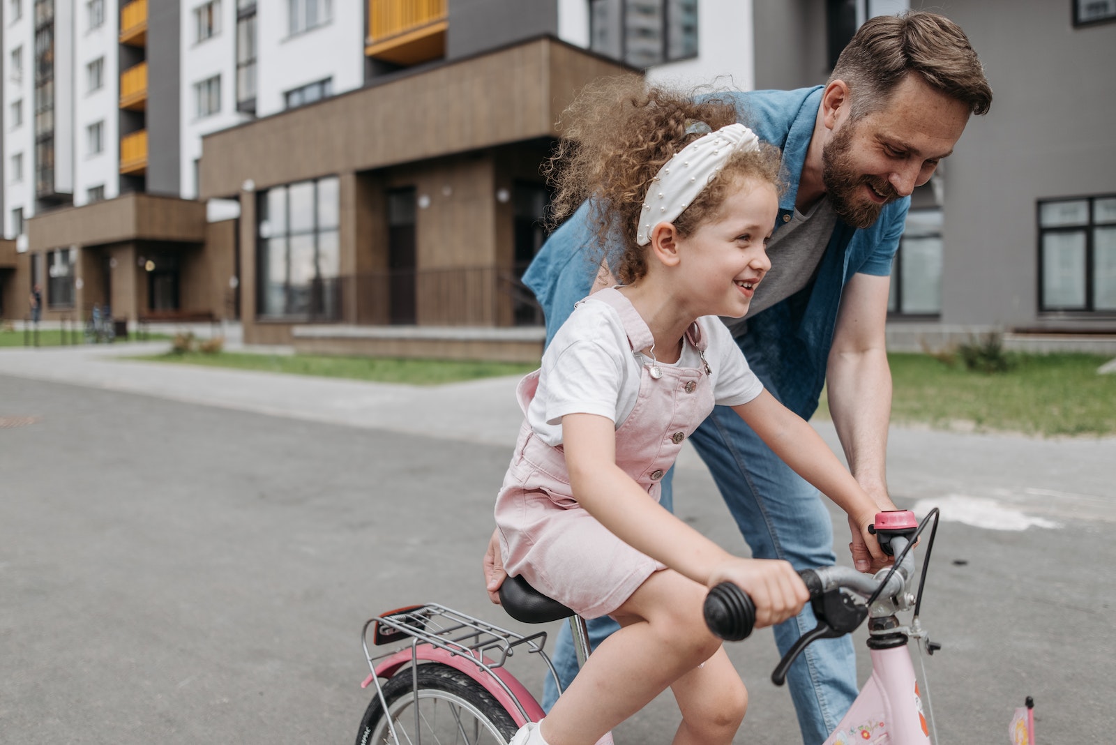Girl Learning How to Ride a Bicycle with her Dad